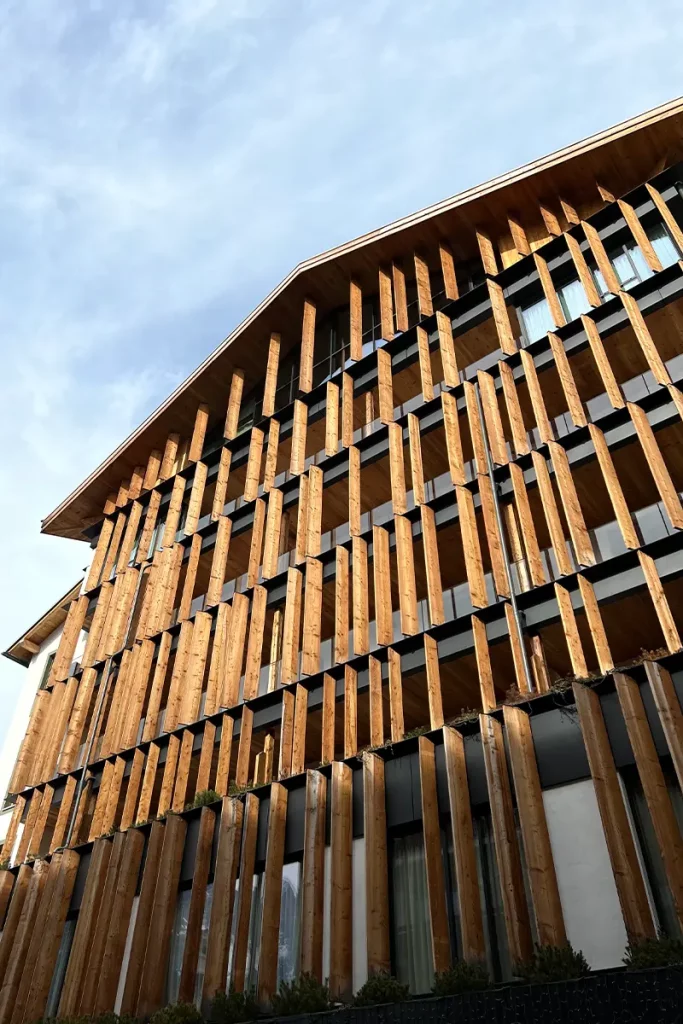 wooden boards cover the façade of Hotel de Len, Cortina d'Ampezzo. Arranged vertically in a series, they all face the mountain